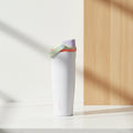A white Owala travel tumbler with a coral-red flip-top lid and carrying loop, shown on a solid white background.