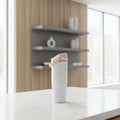 A Owala insulated water bottle with a light gray body, a pastel green carrying loop, a coral orange band, and a lavender lid, shown on a solid white background.
