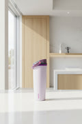 A light lavender Owala travel tumbler with a purple flip-top lid and a pink brand logo printed vertically near the bottom.