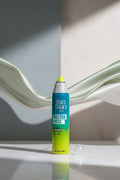 A can of Bed Head Tigi Master Piece Extra Strong Hold hairspray with a green and blue gradient design, shown with its clear cap off on a white background.