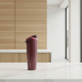 Brown water bottle with pink cap on a white background