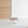 A Kilner glass jar with a metal clamp lid and orange-red rubber gasket, shown on a plain white background.
