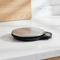 Digital kitchen scale with a clear lid on a white background