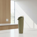 Green insulated bottle with a white cap on a white background