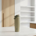 Green insulated bottle with a white cap on a white background