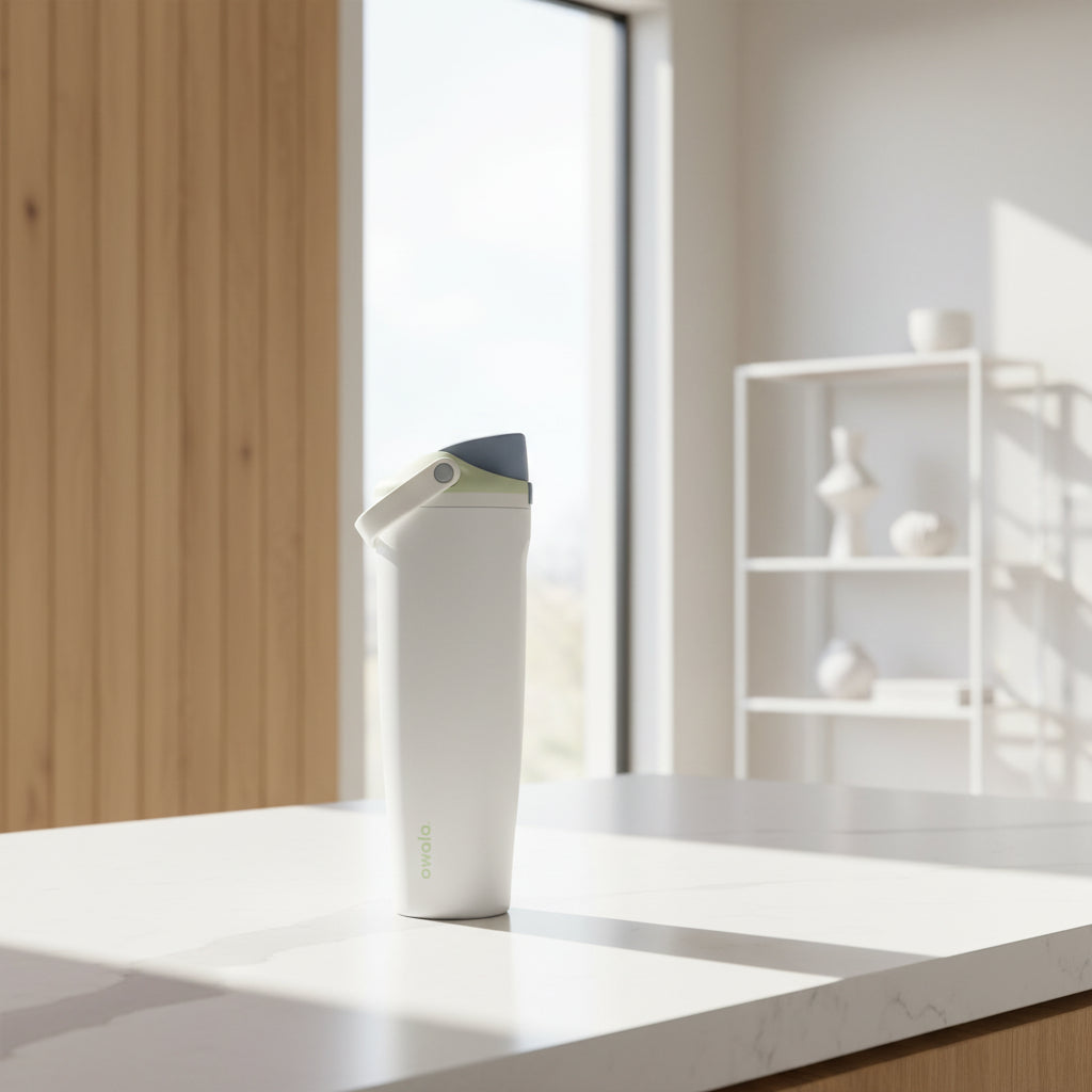 Gray insulated drink container with a white lid on a white background