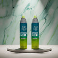 Two bottles of Tigi Bed Head Master Piece hair styling spray side by side on a white background.