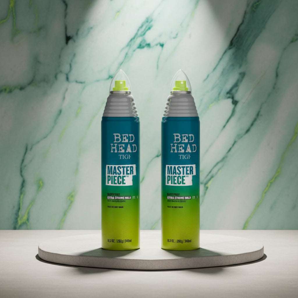Two bottles of Tigi Bed Head Master Piece hair styling spray side by side on a white background.