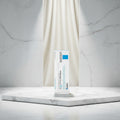 La Roche-Posay Cicapiast Baume B5+ cosmetic packaging card, featuring a white background with blue and black text, a blue square logo block, and the Microbiome Science brand logo.