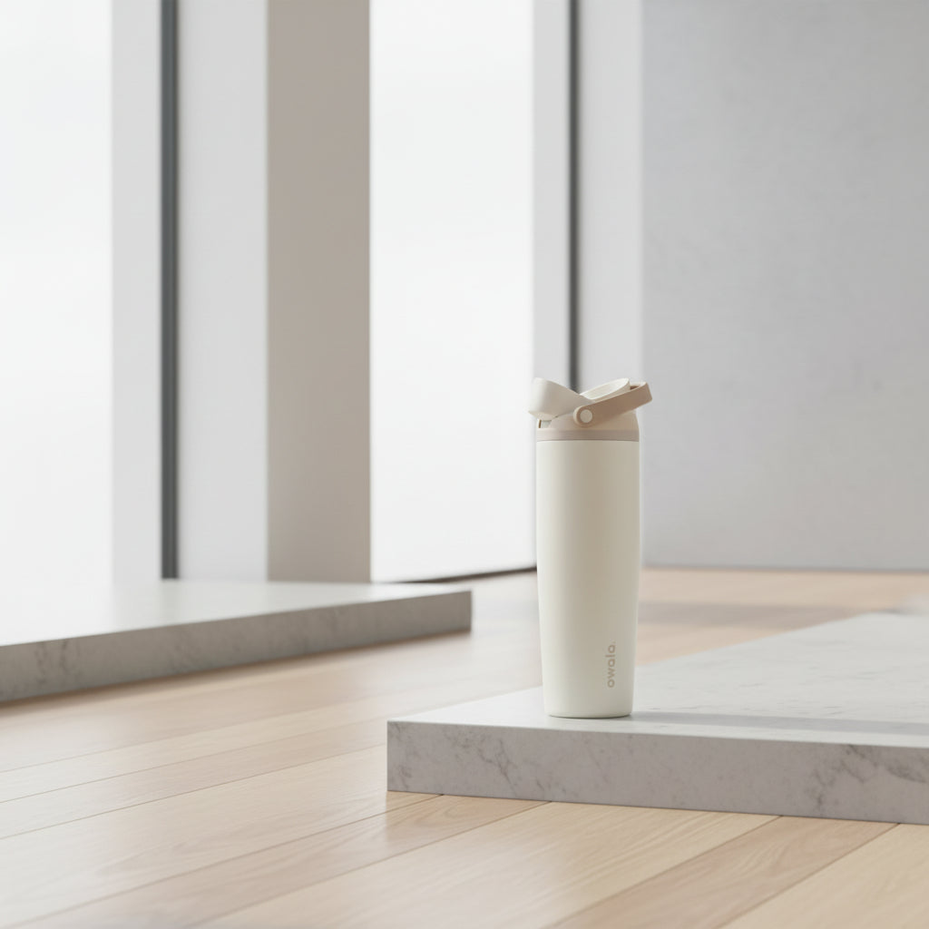 Woman drinking from a white tumbler with mountains in the background