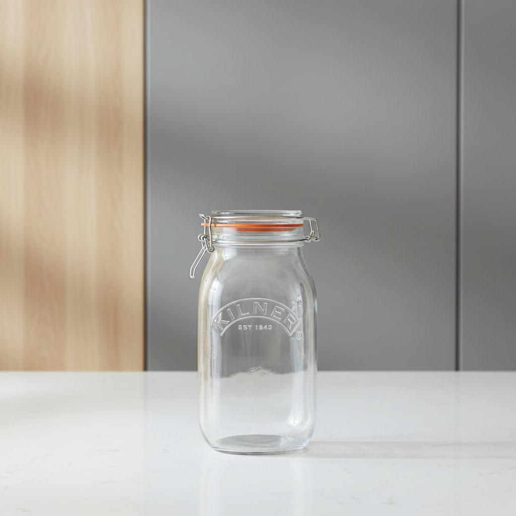A clear Kilner glass jar with a metal clamp lid and orange-brown rubber gasket, shown on a white background with dimension lines indicating 25.4 cm height and 12.