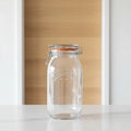 A clear Kilner glass jar with a metal clamp lid and orange-brown rubber gasket, shown on a white background with dimension lines indicating 25.4 cm height and 12.
