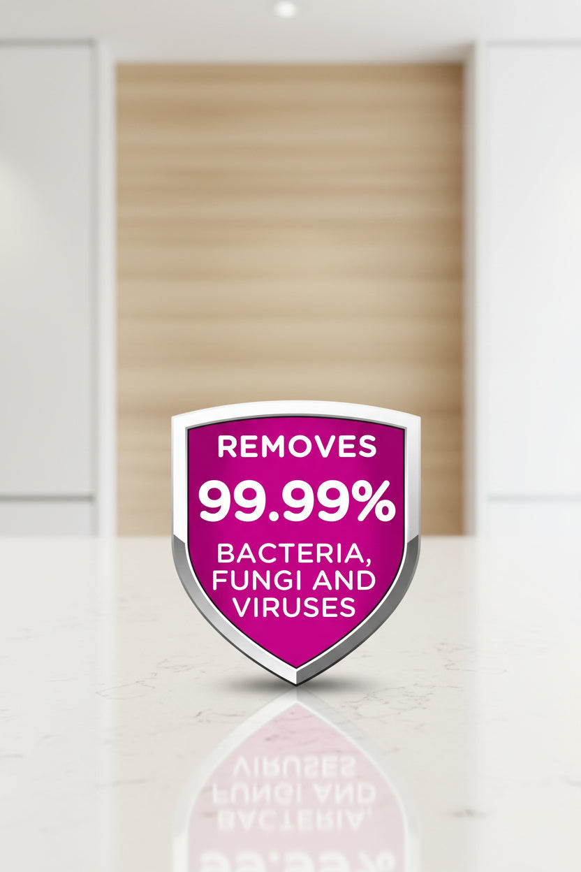 Shield-shaped logo with text indicating the removal of 99.99% bacteria, fungi, and viruses on a pink background.