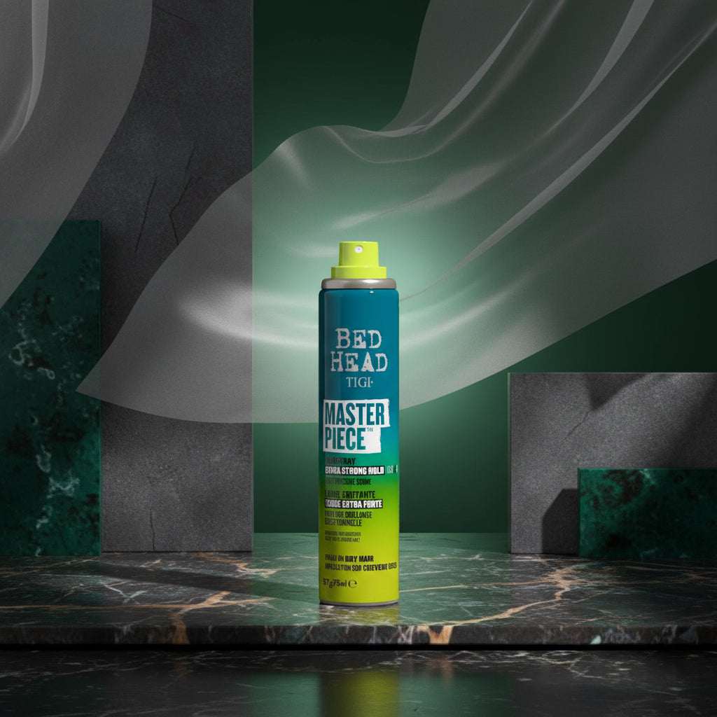 Tigi Bed Head Master Piece Hair Spray can in a teal-to-yellow gradient design with a lime green spray top, shown alongside a clear plastic cap on a white background.