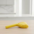 Yellow kitchen tool with multiple components on a white background