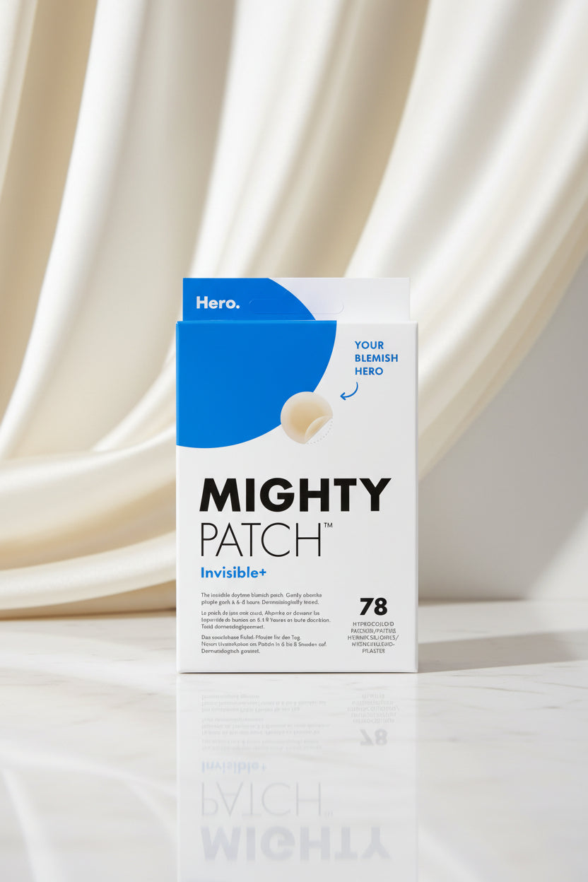 Front of a Mighty Patch Invisible+ product box with a white background, blue graphic shape, large black brand text, and a small inset showing the patch itself.