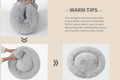 A four-panel product infographic showing a fluffy light gray circular cushion or pet bed, with text reading 'WARM TIPS' and instructions about vacuum compression and shaking to restore fluffiness.