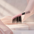 Flex tower brush with pink bristle head and black shaft on a light blue background