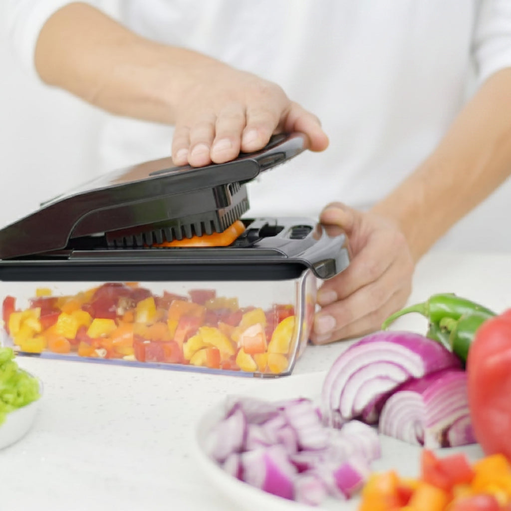 Person using a food processor with vegetables on a white background, featuring the 'fullstar' brand.