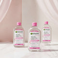 Three 700ml bottles of Garnier Micellar Cleansing Water All-in-1 Sensitive Skin, arranged in a triangular composition on a plain white background.