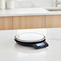 Digital kitchen scale with a metallic surface on a white background