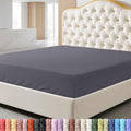 Brown fitted sheet on a bed with a decorative headboard and nightstand.