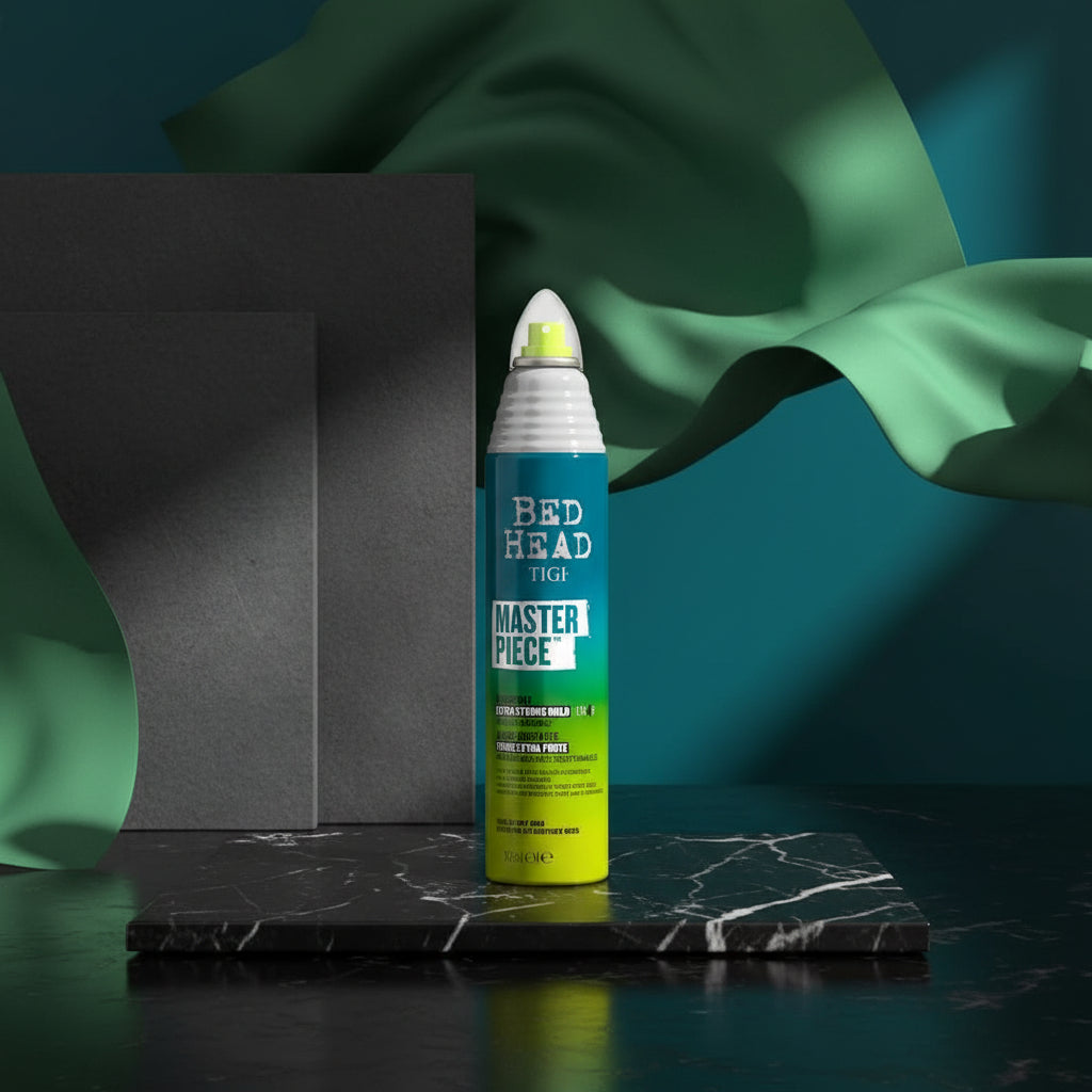 A can of Bed Head Tigi Master Piece Extra Strong Hold Hairspray is centered against a bold graphic background with teal, lime green, black, and white text blocks. The spray can has a blue-to-yellow gradient label and a white nozzle.