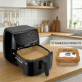 Black air fryer on a kitchen counter with bread baskets and measurements displayed.