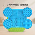 Blue and green silicone mat with four different textured sections on a white background.