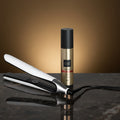 Hair straightener and bottle with text on a black background
