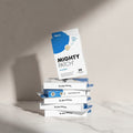 Mighty Patch packaging with hydrocolloid information on a blue tiled wall background