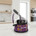 A kitchen knife being sharpened on a purple Any Sharp electric sharpening machine with yellow sunflower graphics, shown on a white background with a motion arrow overlay.