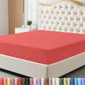 Red fitted sheet on a bed with a headboard and nightstand in a bedroom setting.