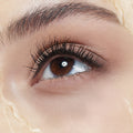 Close-up of an eye with long, voluminous lashes and text 'LONGUEUR ILLIMITÓéE & VOLUME' on a beige background.