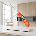 An orange digital meat thermometer with multiple long metal probes, shown with promotional text and graphics explaining its auto-on feature and rotating probe. The background is a blurred grill scene.