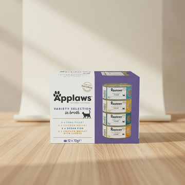 Box of Applaws natural cat food variety selection in broth with cans displayed.