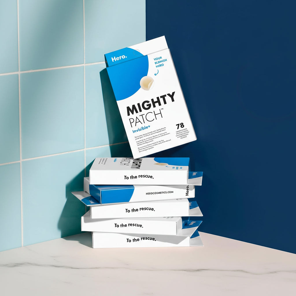 A stack of Mighty Patch hydrocolloid blister packs displayed against a dark blue background with light blue tiled wall panels on the left. White text on the right reads 'Just one powerful ingredient' and 'Hydrocolloid,' with bullet points noting 'Medical grade,' 'Dermatologically tested,' and 'Suitable for sensitive skin.