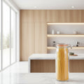 Person holding a jar of spaghetti with a spoon in a kitchen setting