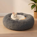 Cat lying on a fluffy gray pet bed against a white background