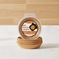 A pack of 100 unbleached brown paper air fryer liners, shown in a clear plastic clamshell container with a printed label, alongside several lifestyle inset images demonstrating the liners in use inside air fryers and holding cooked food.