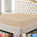 Beige fitted sheet on a bed with a decorative headboard and nightstand in a bedroom setting.
