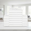 A stack of folded white bedding, including pillows and sheets, arranged symmetrically against a plain white background.