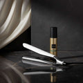 Hair straightener and bottle with ghd logo on a black background