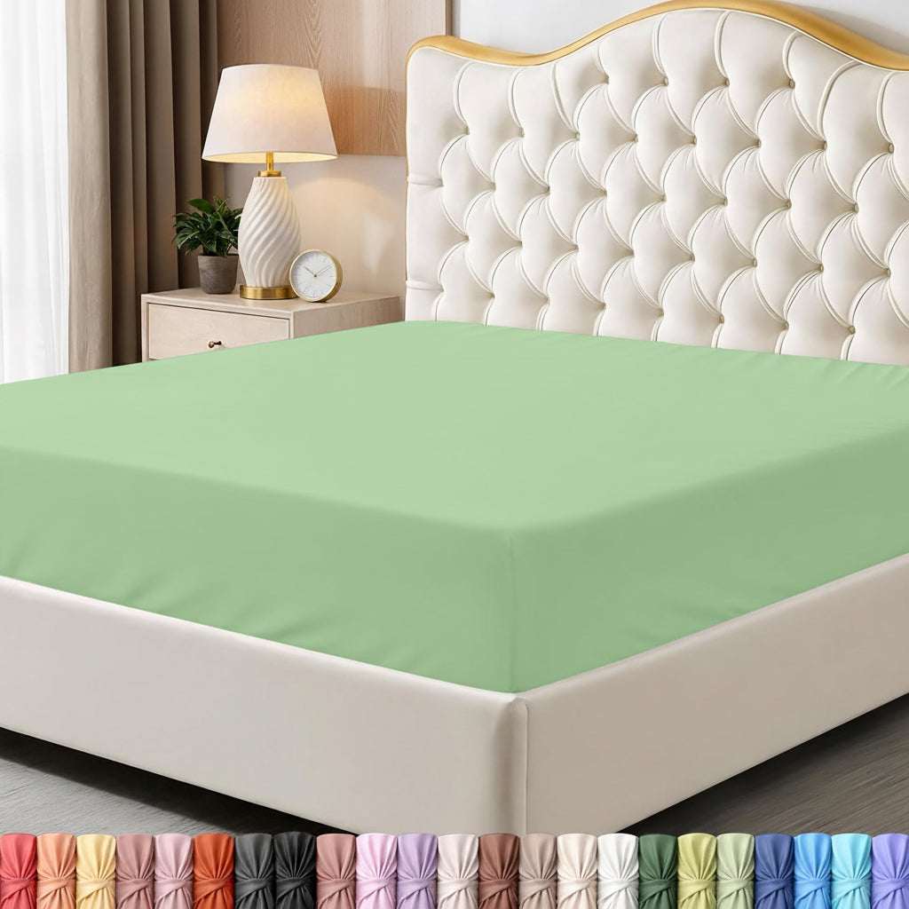 Green bed sheet on a neatly made bed with a decorative headboard and nightstand.