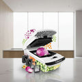 White and black Fullstar vegetable chopper and slicer countertop appliance shown open with a red onion inside, surrounded by inset graphics of different blade attachments and chopped vegetables on a white background.