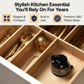 A kitchen drawer organizer made of light natural wood with divided compartments holding gold-toned utensils and a small black-and-silver kettle. Text at the top reads 'Stylish Kitchen Essential You'll Rely On For Years' with feature callouts: Elegant & Compact, Built to Last, and Premium ABC Plastic Base.