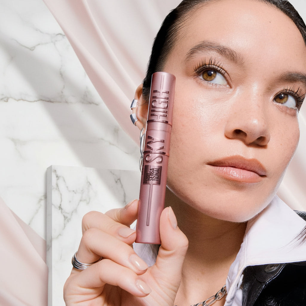 Woman holding a pink mascara with text about lash impact and product features.