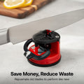 Red and black knife sharpener on a kitchen counter with text 'Save Money, Reduce Waste'.