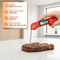 Red digital thermometer inserted into a piece of meat with cooking details and product features displayed.