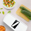 White kitchen appliance with black component on a table with vegetables and salad, featuring 'fullstar' branding.
